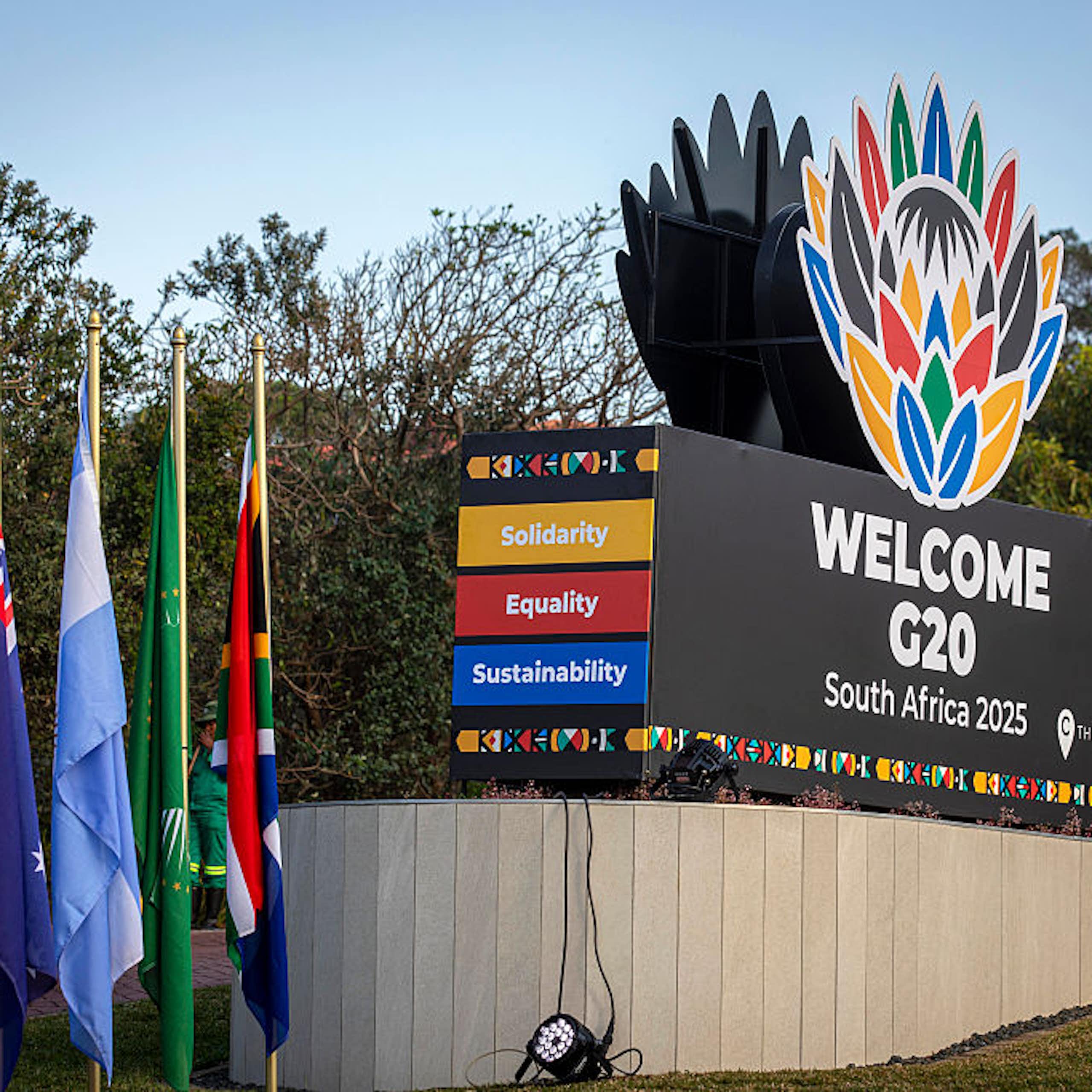 Signage showing different coloured flags and a large block written 'Welcome G20 South Africa'