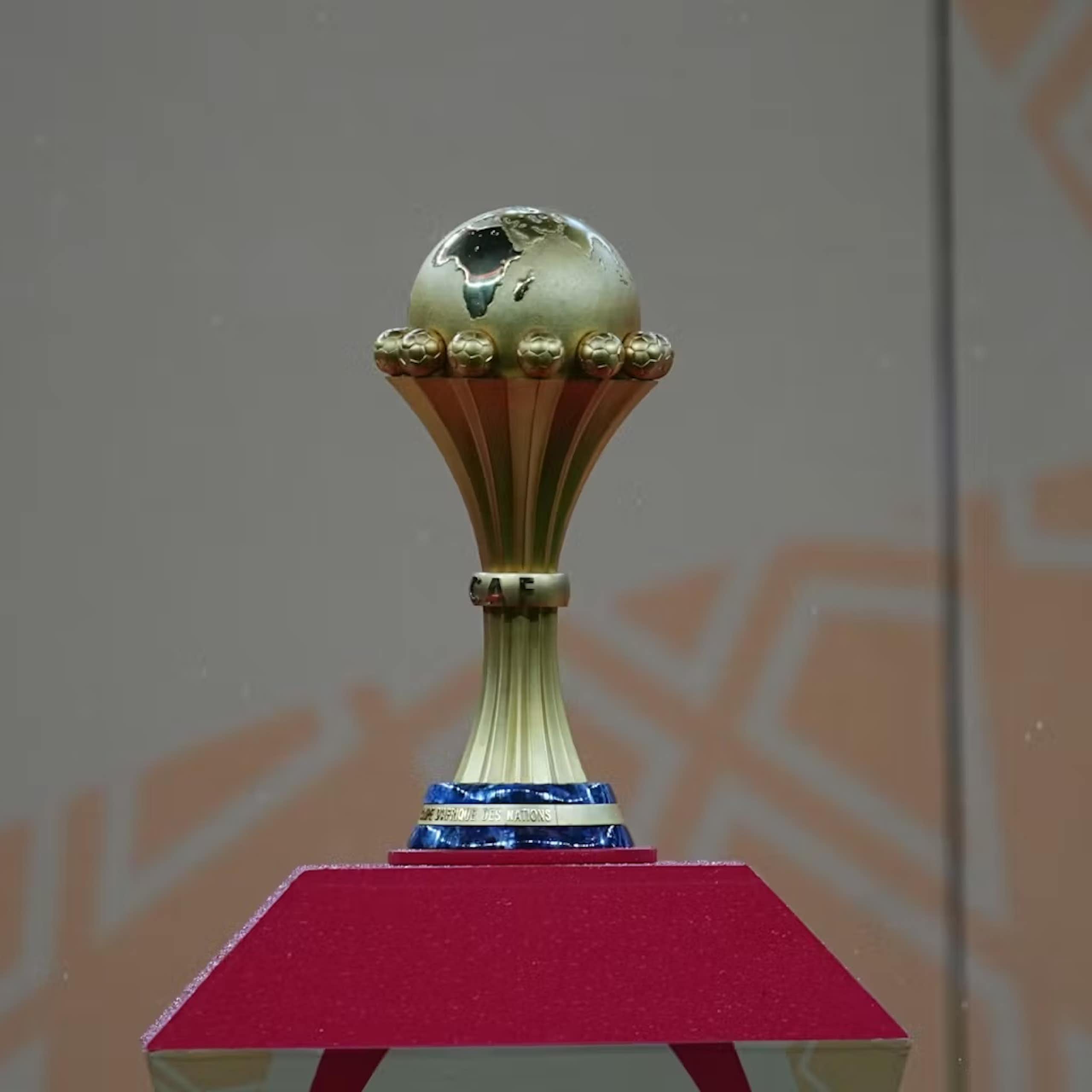 A football trophy featuring a globe cradled with the map of Africa prominent.