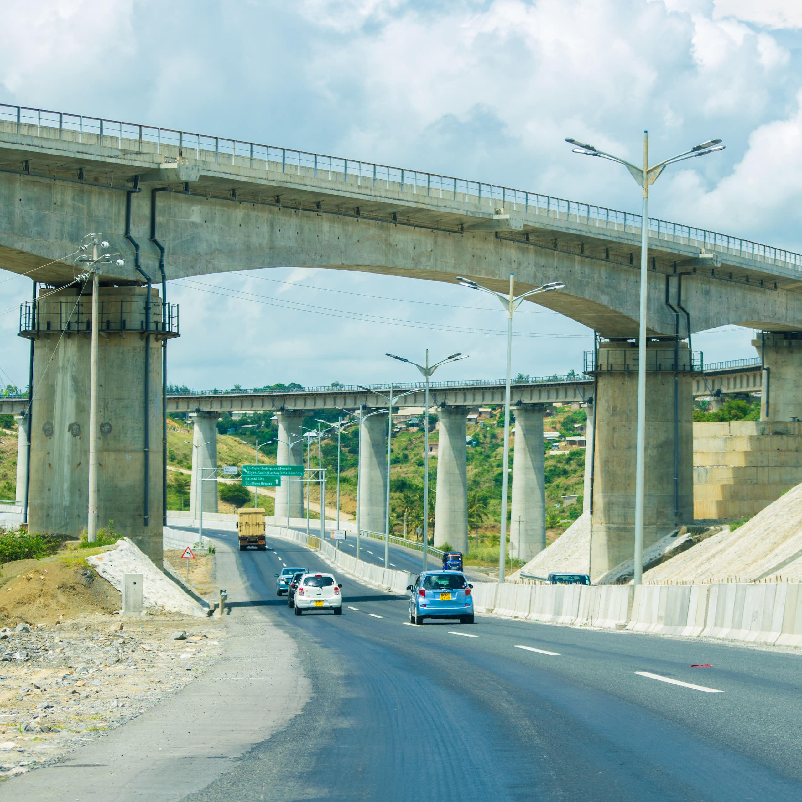 Cars on the road under a railway overpass bridge 