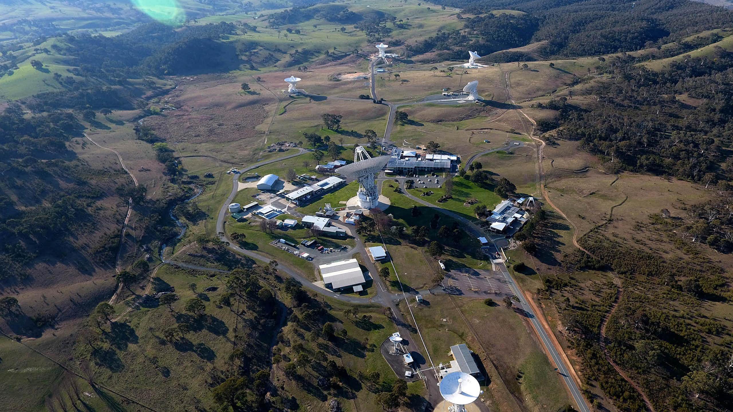 Aerial view of an Australian landscape with space signal dishes and support buildings.
