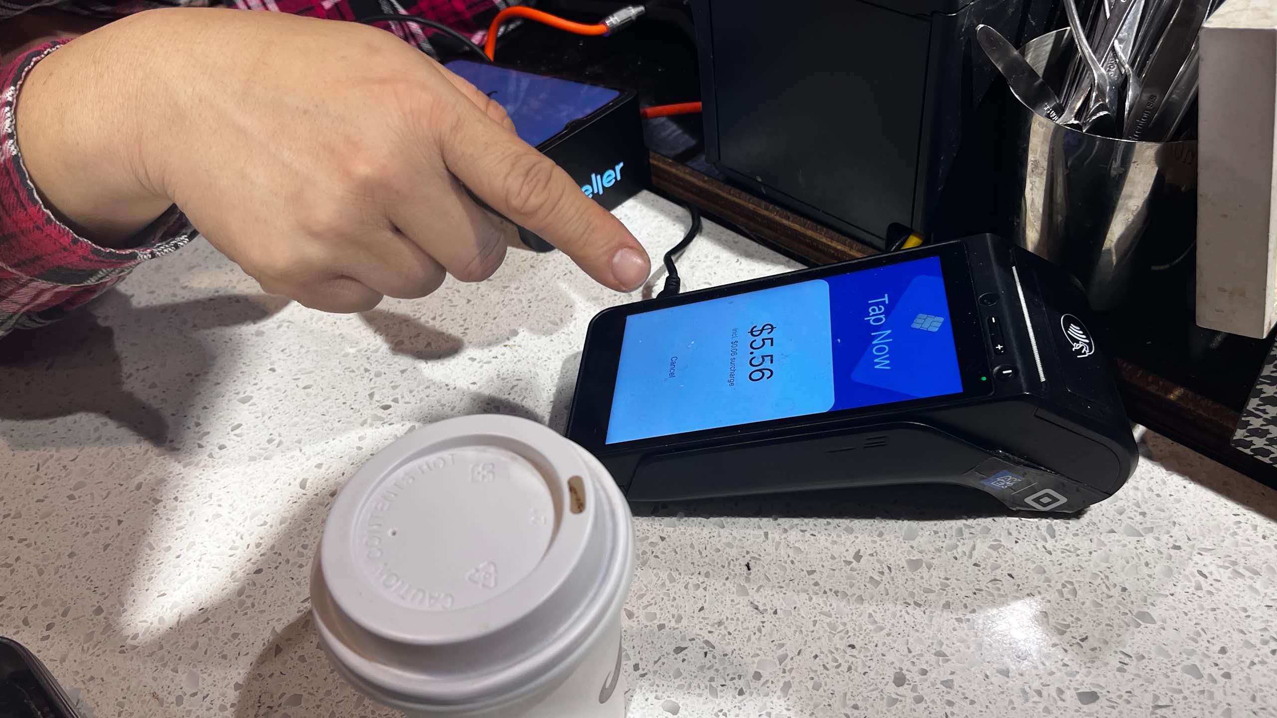 Someone about to pay for a coffee at a Sydney cafe