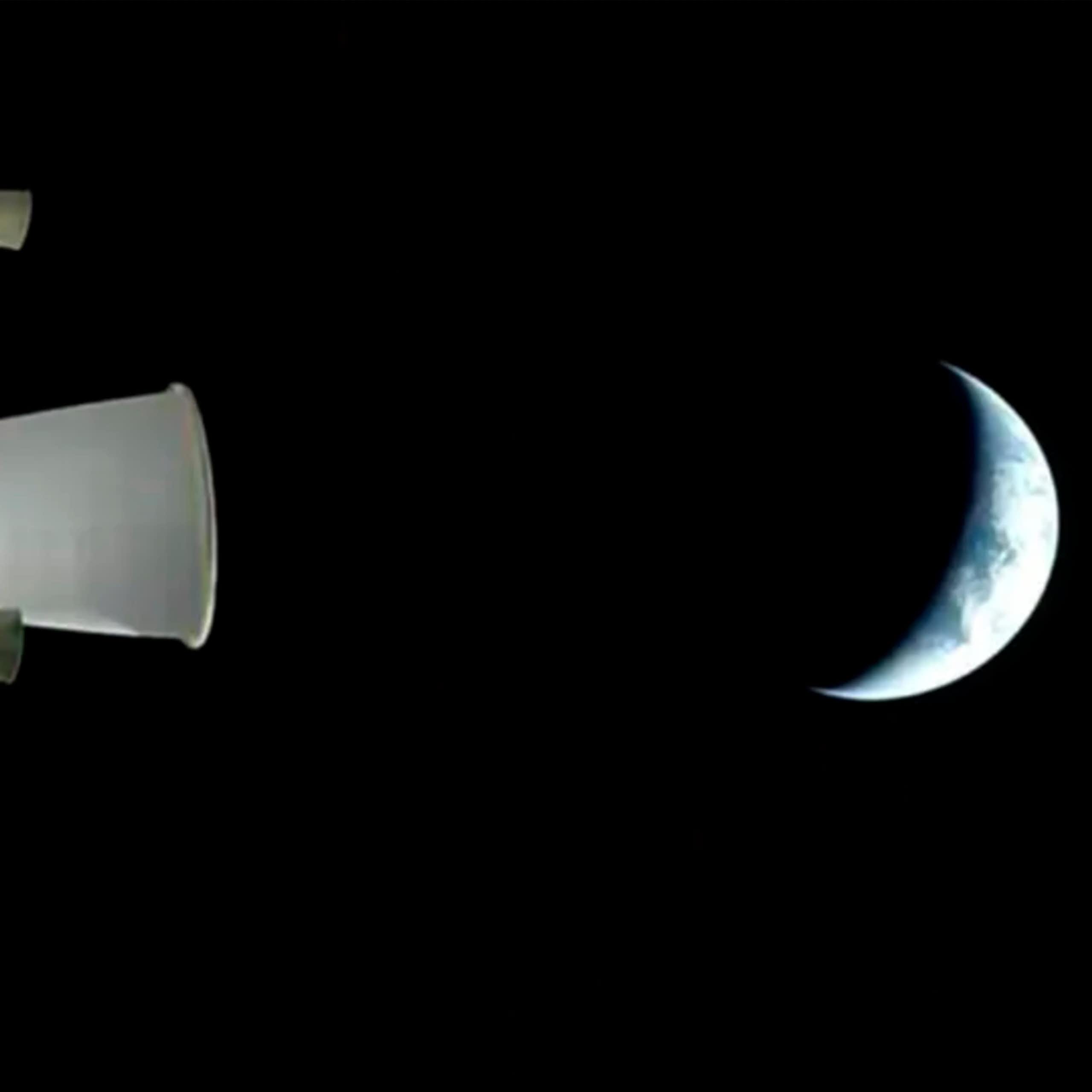 The Earth seen from a distance in space. Only a crescent of it is visisble; the rest is in shadow