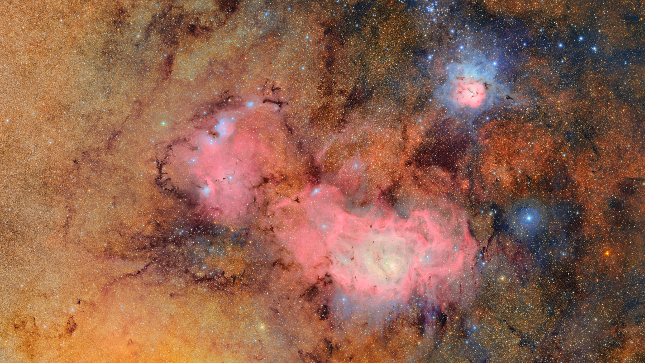 Bright clouds of pink and orange dust, surrounded by stars. 