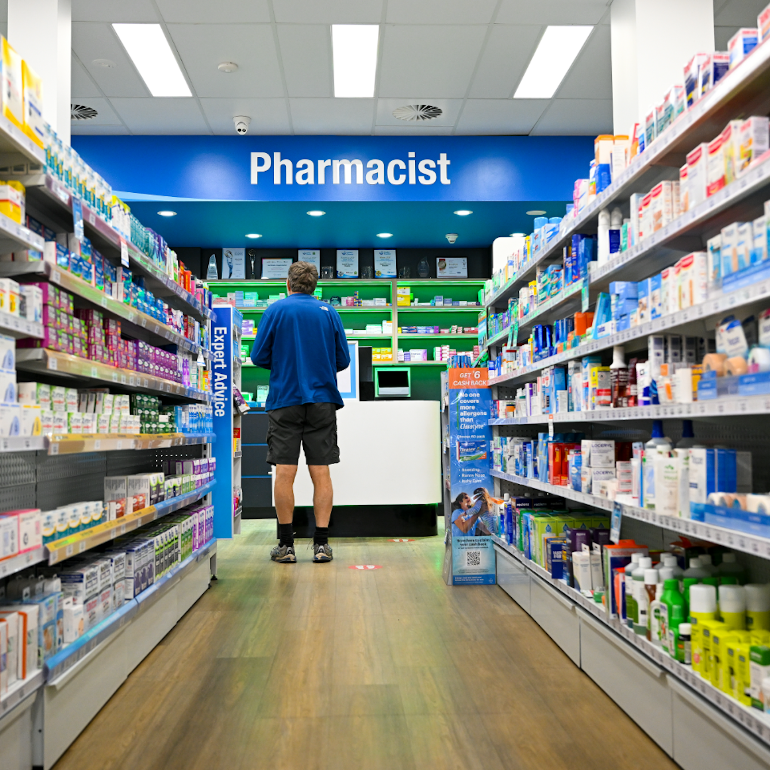 Man waits to get his prescription filled at a pharmacy